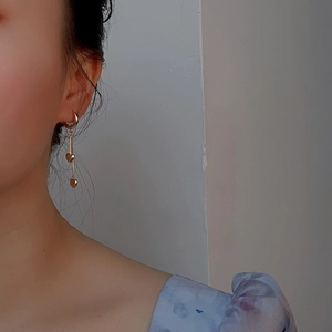 Vue rapprochée d'élégantes boucles d'oreilles cœur dorées portées par un mannequin