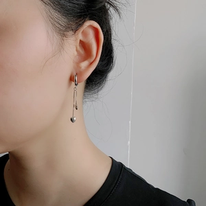 Détail de boucles d'oreilles en argent S925 avec pendentif cœur sur chaîne fine