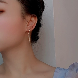 Élégantes boucles d'oreilles pompons en argent S925 doré portées par un mannequin