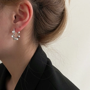 S925 sterling silver wavy hoop earrings with a textured crinkle design on a female model
