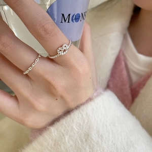 Close-up of S925 sterling silver twisted knot and chain rings on woman's hand