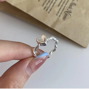Detailed macro shot of an adjustable S925 silver twist ring with a central heart design