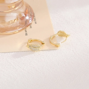 Vue détaillée de boucles d'oreilles dorées en forme de feuille avec zircons micro-paves
