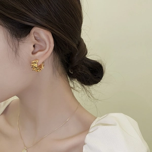 Élégantes boucles d'oreilles créoles dorées multicouches portées par un mannequin chic