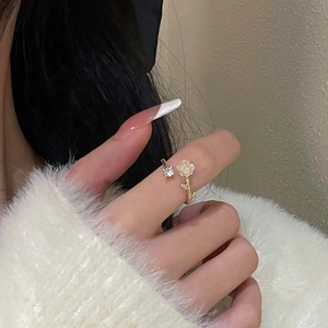 Detailed view of adjustable golden ring with white camellia flower and zircon stone
