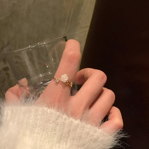 Detailed shot of white camellia open ring with zircon inlay and gold-plated finish
