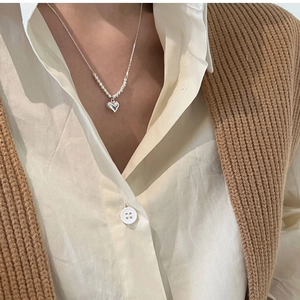 Detail of S925 sterling silver heart pendant necklace worn on model neck