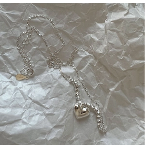 Elegant S925 sterling silver heart pendant necklace with beads on textured background