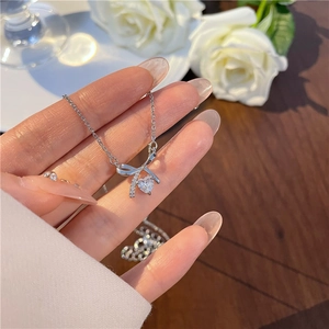 Detail of s925 silver bow necklace featuring a sparkling heart zircon pendant for women
