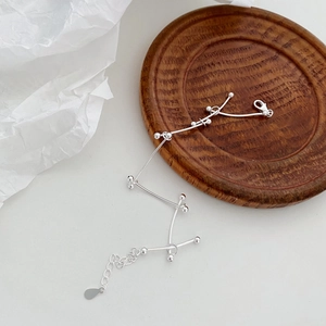 Detail of S925 silver minimalist bracelet with geometric bead bars and lobster clasp