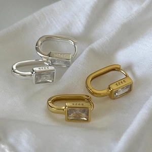 Detailed macro of S925 sterling silver geometric huggie earrings with zircon inlays