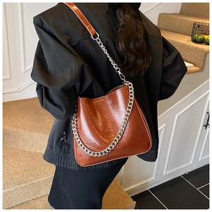 Brown patent leather bucket bag with silver chain detail and pleated design for women