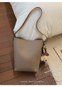 Detail of grey bucket bag with lychee pattern leather and cute leopard bow charm