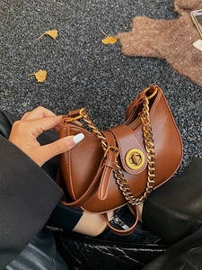 Vintage caramel brown chain hobo bag with gold ring clasp and autumn leaf background