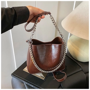 Detail of vintage brown bucket bag with silver chain handle and adjustable strap