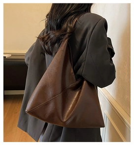 Detail of large dark brown tote bag with geometric stitching on soft synthetic leather