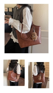 Detail view of large vintage brown tote bag with fashion lettering and bear pendant