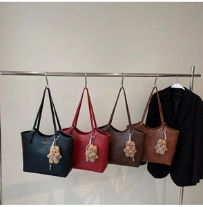 Close-up of vintage large leather tote bags in four colors with plush dog charms