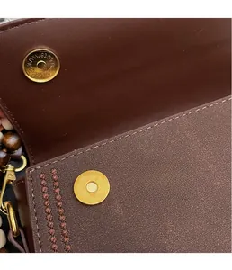 Detailed macro view of gold magnetic clasp and premium leather stitching on crossbody bag