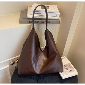 Detail of vintage dark brown tote bag showing crinkled leather texture and stitching