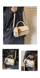 Detail of retro cream square bag featuring wooden bead charm and adjustable strap