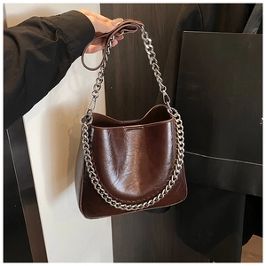 Detail of burgundy glossy leather tote bag with thick silver chain and shoulder strap