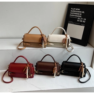 Group view of vintage matte crossbody bags with ethnic bead tassels on marble steps