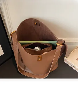 Spacious interior of brown lychee grain bucket bag with laptop and inner pouch