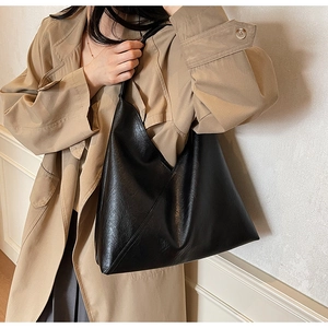 Classic black leather tote bag worn over the shoulder with an oversized hobo design