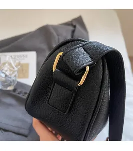 Dettaglio della borsa in pelle martellata nera con anello a D dorato e cuciture rifinite