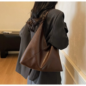 Deep caramel leather tote bag shown from a side back view on model for daily commute