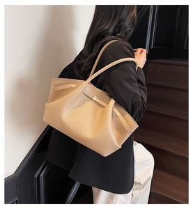 Chic beige textured leather tote bag with soft pleats and metal buckle on shoulder