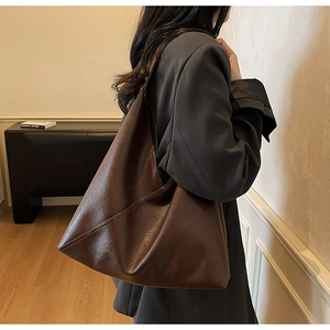 Detail of vintage dark brown tote bag with matte leather texture and wide strap design