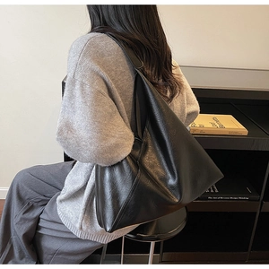 Detailed view of black minimalist tote bag with polished faux leather and natural texture