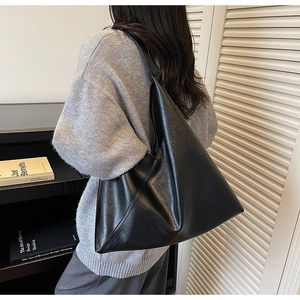 Detail view of large black vintage tote bag showing texture and oversized shoulder fit