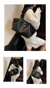 Detail view of large black pebble leather tote bag with elegant gold metal clasp