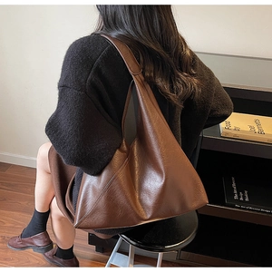 Brown vintage faux leather tote bag showing large capacity and soft texture on model