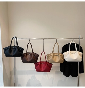 Litchi pattern textured tote bags in five colors hanging on a metal rack for display