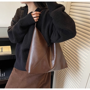 Macro shot of dark brown large capacity faux leather shoulder bag with vintage texture