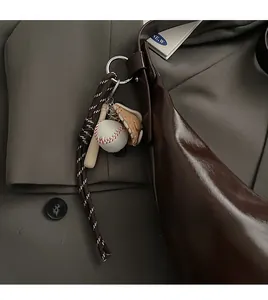 Detail of baseball theme charm set with bat, glove, and ball on a leather bag handle