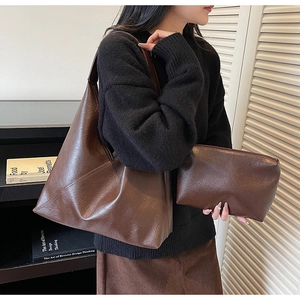 Detail of vintage brown leather tote bag with matching zipper pouch and V-stitch pattern