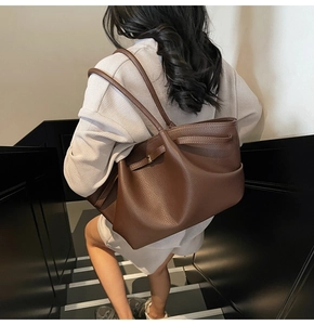 Detailed view of deep brown pebbled leather tote bag worn as a stylish shoulder bag