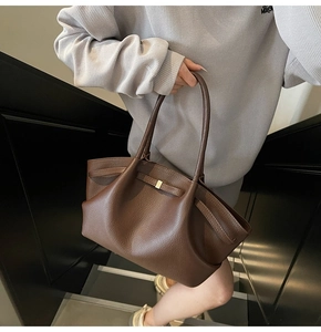 Detail of premium brown lychee grain leather tote bag with elegant metal buckle closure