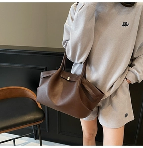 Close-up of deep brown tote bag with high-quality lychee texture and natural leather folds