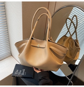 Close-up of pebble grain leather texture and gold hardware on beige tote bag