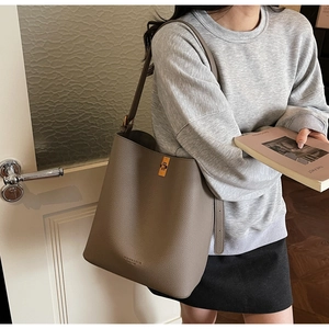 Detailed close-up of litchi grain leather bucket bag with golden twist lock and logo