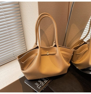 Detail of light tan lychee grain leather tote with pleated design and metal hardware
