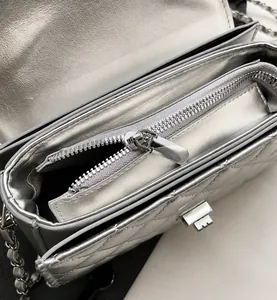 Gros plan sur la fermeture éclair en métal et la poche intérieure du sac argenté