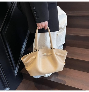 Detail of apricot large tote bag in lychee texture leather with silver metal buckle