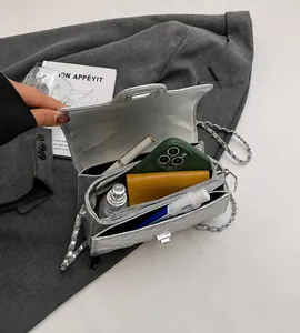 Détail du sac argenté matelassé montrant l'intérieur compartimenté et la chaîne métal